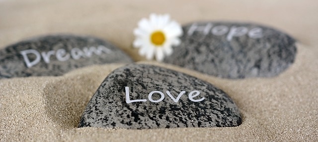 Steine liegen im Sand, darauf steht Dream, Love, Hope