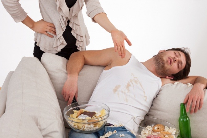 Ein Mann schläft mit Essen auf der Couch