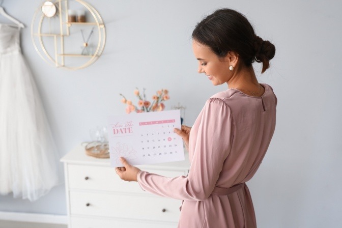 Glückliche Frau mit Kalender in der Hand plant Date mit Urlaubsflirt.