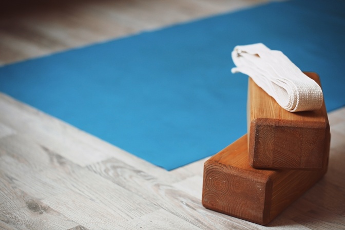 Klötze und Matten für Iyengar Yoga liegen auf einem Platz