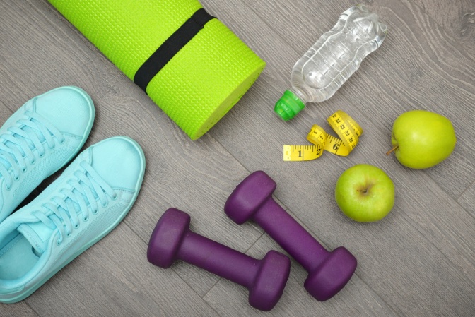 Turnschuhe, Hanteln, Wasserflasche und zwei Grapefruithälften