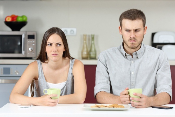 Ein Paar sitzt verärgert beim Tisch