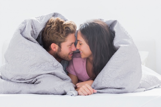 Ein Mann und eine Frau sind verliebt unter einer Decke