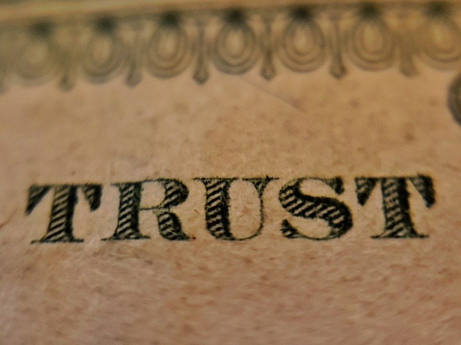 Eine Nahaufnahme eines Tattoos, das aus dem Wort Trust besteht.
