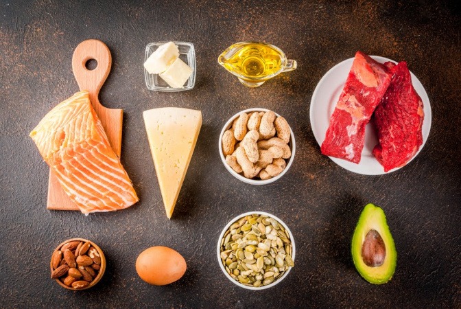 Lebensmittel wie Lachs, Avocado und Käse, die Vitamin B enthalten. 