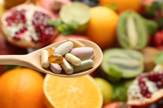 Vitamintabletten auf einem Löffel