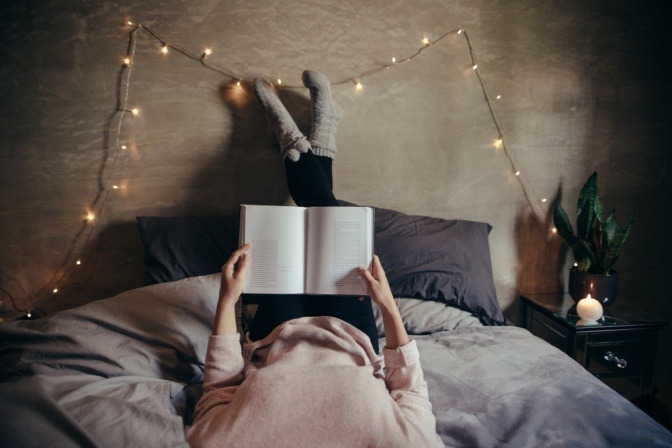 Frau bei Vollmond mit Buch im Bett