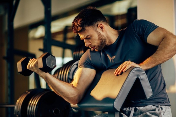 Mann trainiert mit Gewicht im Fitnessstudio.