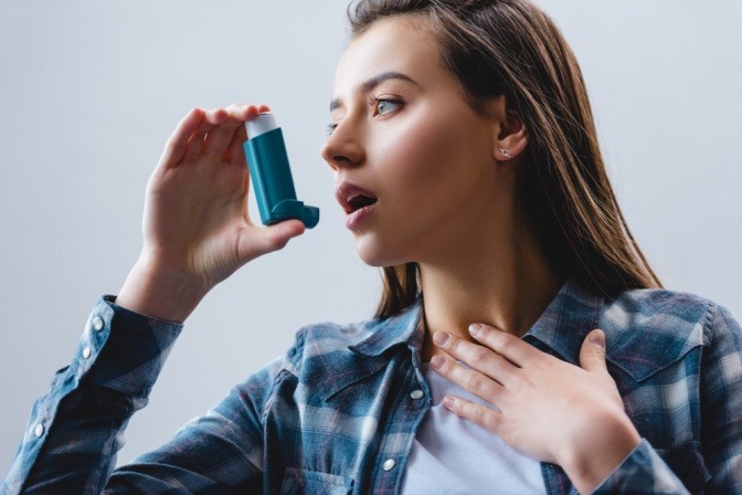 Frau mit Inhalator gegen Asthma