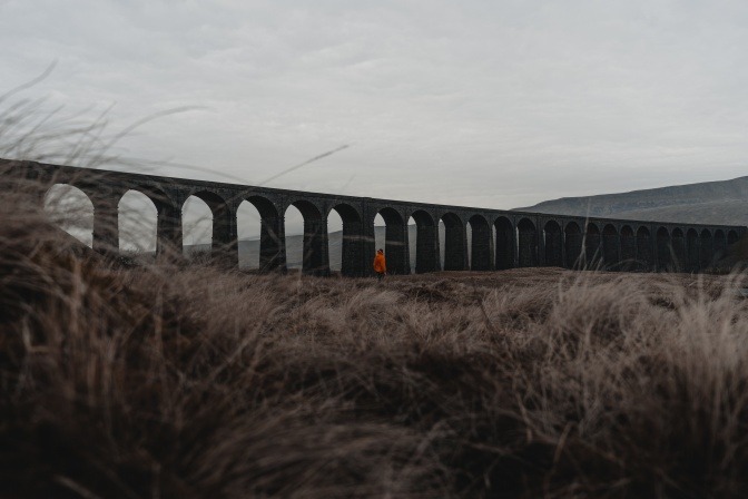 Ein Mensch ist einsam neben einer großen Brücke