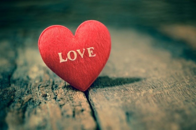 Ein kleines rotes Plüschherz mit der Aufschrift Love.
