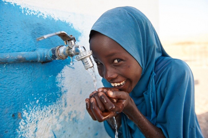 Ein Mädchen trinkt Wasser aus einem hygienisch einwandfreien Wasserhahn