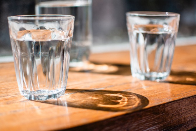 Zwei Gläser mit Wasser zum Trinken stehen auf einem Tisch