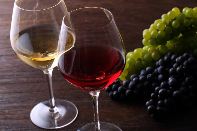 Weingläser stehen neben Weintrauben