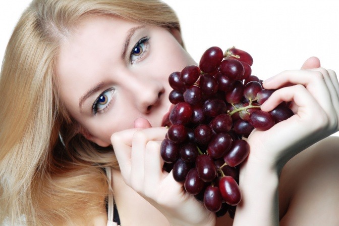 Eine Frau isst Weintrauben weil sie eine Weintraubenkur machen will