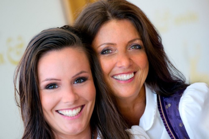 Zwei Frauen mit weißen Zähnen lächeln