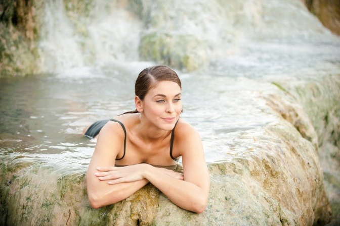 Eine Frau im Wasser macht Wellness-Urlaub