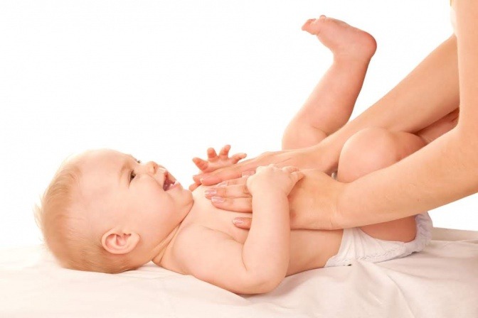 Eine Frau wickelt den Po eines Babys