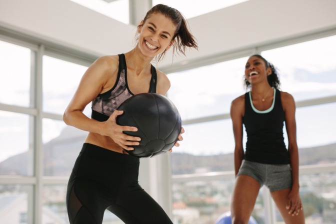 Zwei lächelnde Frauen beim Fitnesstraining. 