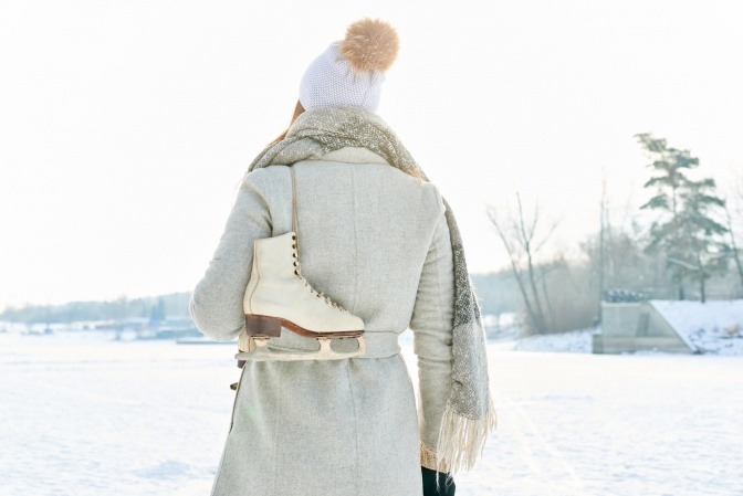 Eine Frau mit Eislaufschuhen ist auf Winterurlaub