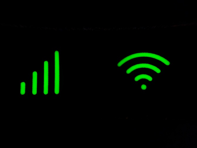 Die beiden gebräuchlichsten WLAN-Symbole in grüner Farbe vor schwarzem Hintergrund.