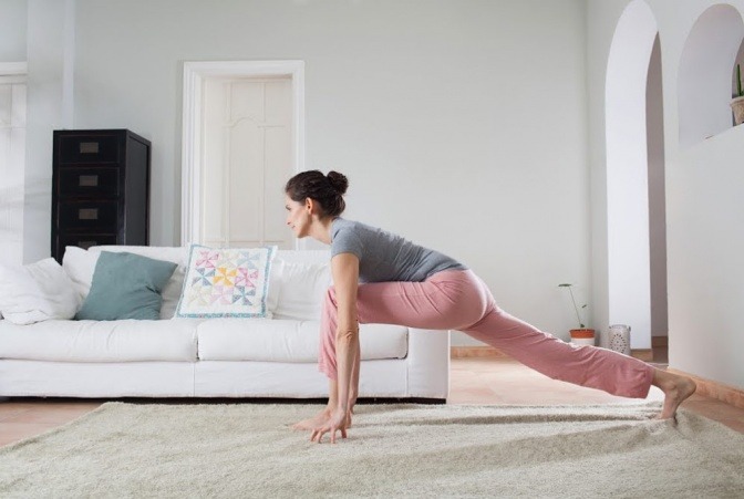 Frau beim Yoga im Wohnzimmer