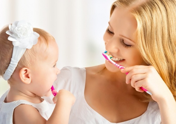Frau mit Kind beim Zähneputzen.