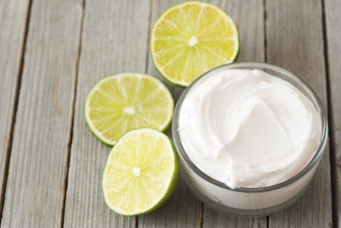 Zitronen liegen neben einer Creme