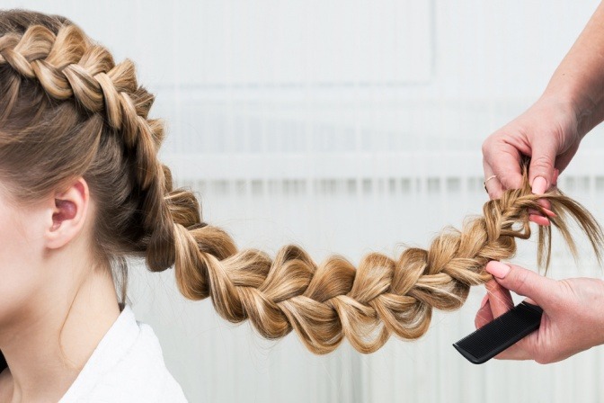 Eine Frau flechtet Haare zu einem Zopf