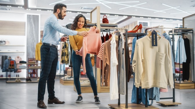 Junge Frau lässt sich beim Shopping für Kleidung für einen Lagenlook beraten. 