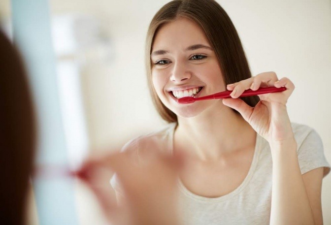 Eine Frau putzt sich mit einer Zahnbürste die Zähne