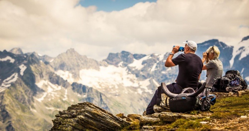 Zwei Wanderer sitzen im Nationalpark Hohe Tauern und trinken