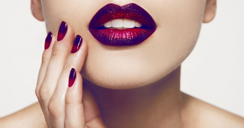 Eine Frau mit roten Nägeln und Lippenstift