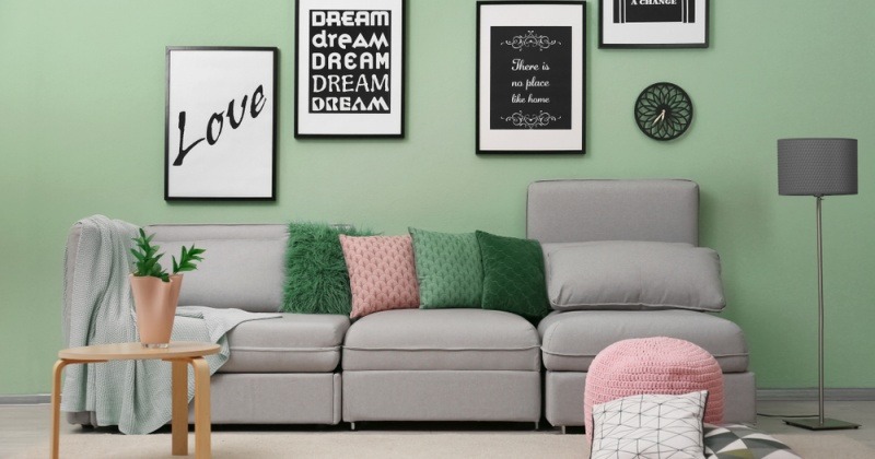 Ein Wohnzimmer hat eine grüne Wandfarbe und viele Bilder