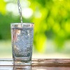 Leitungswasser oder Mineralwasser wird in ein Glas geleert