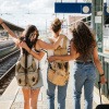 Drei Frauen am Bahnhof in einer Großstadt