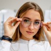 Frau setzt runde Brille als Brillentrend 2023 auf