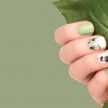 Frauenhand mit grünen Fingernägel im Iced Matcha Nails Trend