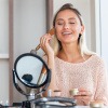 Frau schminkt sich und beherzigt Highlighter-Tipps