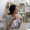 Frau bei der Pause während der Büroarbeit trinkt Kaffee