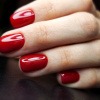 Frau mit roten Nägeln und Russian Manicure
