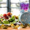 Wecker, Maßband und Salat als Symbol fürs Fasten
