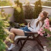 Frau sitzt auf der Veranda und lässt den Alltagsstress hinter sich