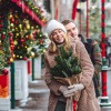 Frau mit ihrem Partner auf dem Weihnachtsmarkt in einem warmen Wintermantel