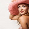Eine hübsche Frau mit einem Hut hat glatte Haut
