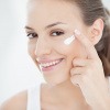 Frau am Morgen mit Creme im Gesicht