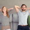 Ein Mann und eine Frau liegen glücklich auf gepolsterten Möbeln, die die Akustik verbessern
