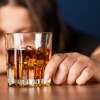 Ein Glas Alkohol vor einer Alkoholikerin 