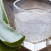 Eine Aloe Vera liegt neben einem Glas mit Aloe Vera Gel