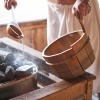 Ein Mann macht einen Aufguss in der Sauna mit ätherischen Ölen